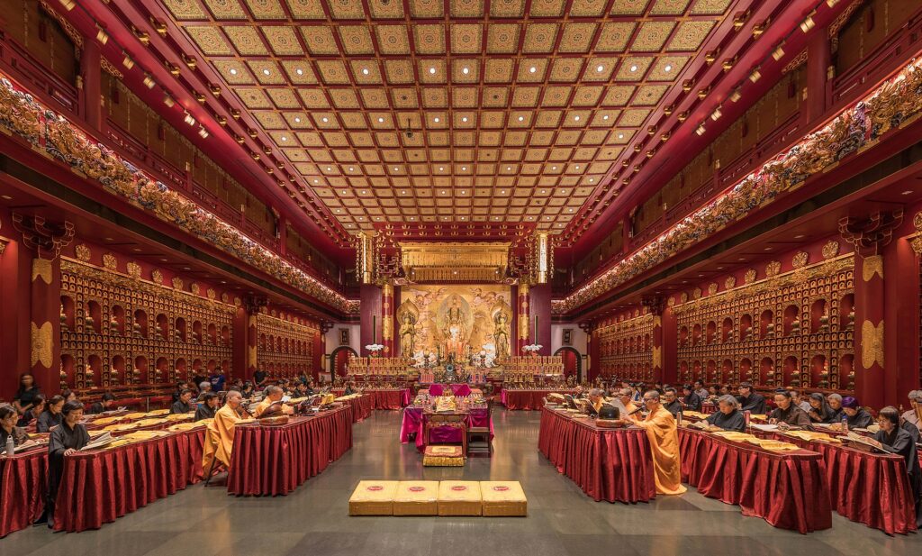 Буддийские монахи и монахини молятся в храме реликвии Зуба Будды в Сингапуре
